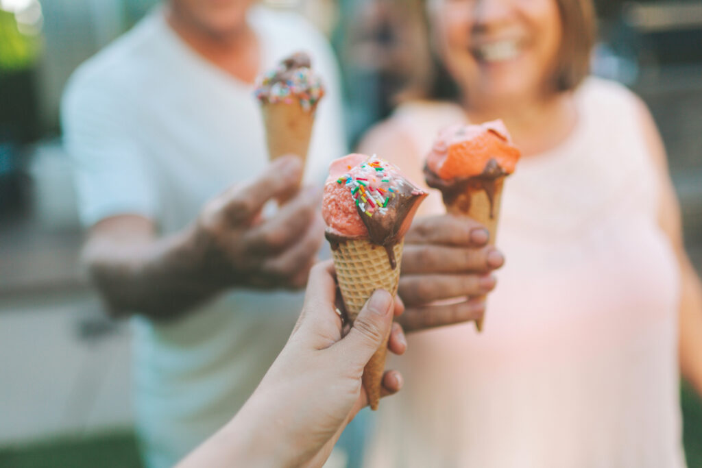 Friends holding ice cream cones on a warm day, representing the best frozen treats franchises for sweet, experience-driven business opportunities.